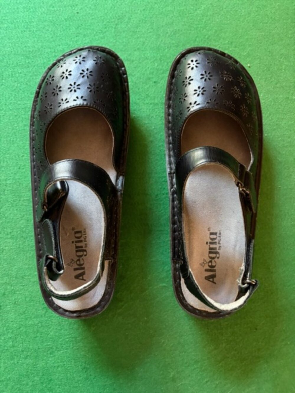 Black leather Alegria shoes size 9.  Velcro strap.  Cutout flower pattern.